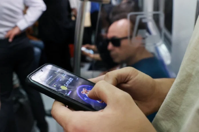 persona jugando hamster kombat en metro