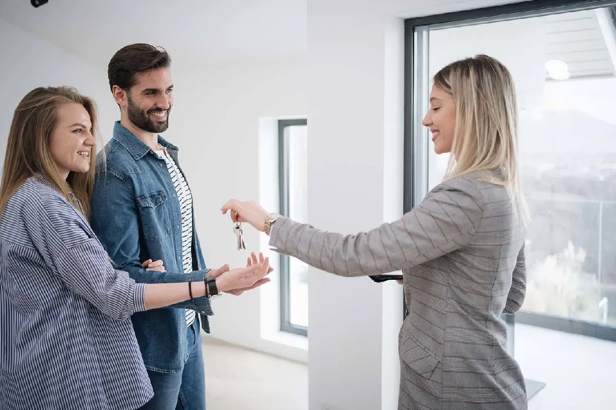 Pareja joven junto a gestor inmobiliario